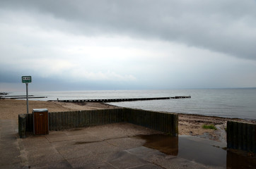 Empty bathing beach in rainy weather, with more rain in the horizon.