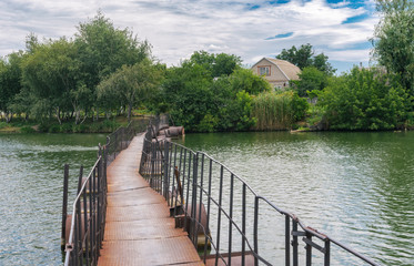 Old pedestrian pontoon-bridge over small river Schemylivka in outskirts of Dnipro city, Ukraine