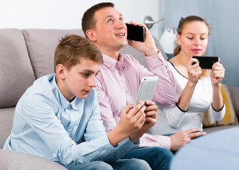 Parents and son using phones