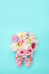 Beautiful gumshoes with flowers inside on bright background