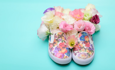Beautiful gumshoes with flowers inside on bright background