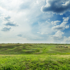 low dramatic clouds over green meadow