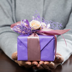 woman received beautiful purple gift box with present. For Mothers Day, Valentines Day and Birthdays