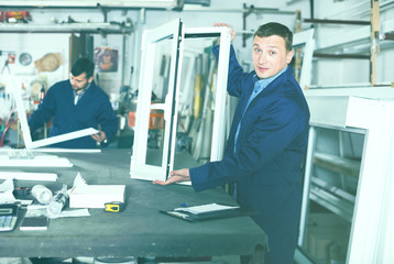 Fototapeta premium mature male surveyor in coverall working with documents at workshop