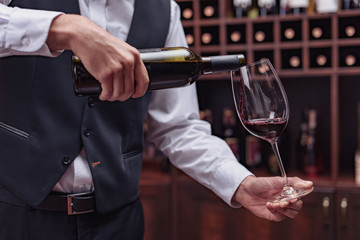 sommelier pouring red wine