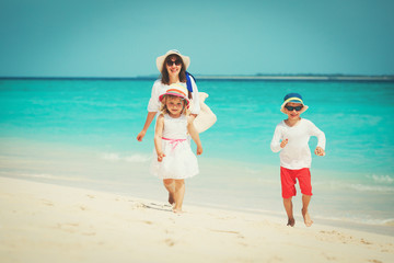 Naklejka premium mother with little son and daughter walk on beach