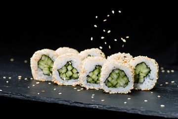 Traditional Japanese cuisine.  Selective focus on sushi rolls with sesame seeds, cream cheese,...