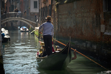 Fototapeta na wymiar Gondoliere in un canale a Venezia