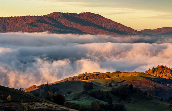 rising clouds in mountainous countryside at sunrise