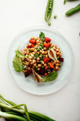 Fresh chickpea salad with mint and vegetables on white rustic background. Healthy lunch concept.  Composition with copy space