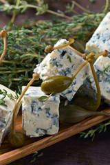 Blue cheese , capers and branches of thyme .