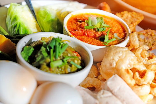 Thai food - Northern style red and green chilli dips with  northern thai spicy sausage (sai oua), streaky pork with crispy crackling and  vegetables