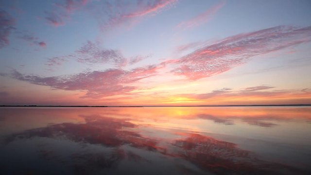 Colorful sunset over calm lake water surface