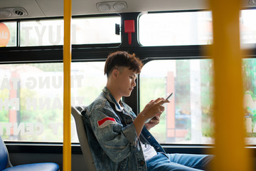 Handsome young man traveling by bus and using a digital tablet