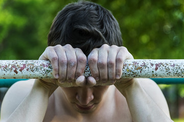 young man holding hands on the horizontal bar