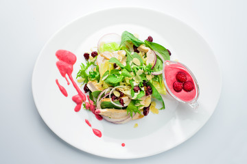 classic Italian food. Salad with chicken in a raspberry sauce on a white plate, light background, top view