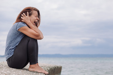 Woman alone and depressed screaming on the bridge