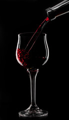 a glass of red wine which is poured on a black background