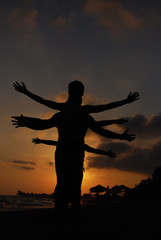 Fototapeta na wymiar Silhouette of one body with lot of hands. Happy family play on summer vacation