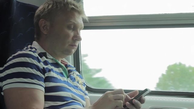 Man Using Smart Phone in a Train