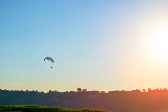 Silhouette of paraglider and evening sky