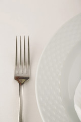 Fork and plate arranged in elegant setting, Selective focus with soft light