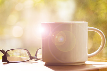 Mug, daisies, Notepad, glasses. The concept of a Sunny summer morning.
