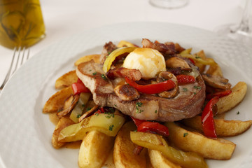 Pork and grilled vegetables arranged on a plate, Traditional dish in elegant setting, Selective focus with soft light