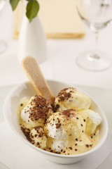 Egg white with vanilla mousse arranged on a plate, Wineglass in background, Traditional dessert in elegant setting, Selective focus with soft light