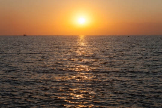 Sun rising over ocean horizon