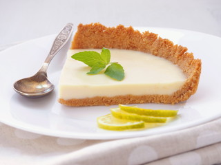 Close up of coffee cake decorated with lime slices and fresh mint. Homemade lemon pudding. Selective focus.