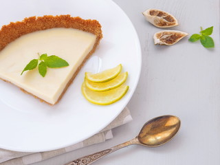 White chocolate tart decorated with lime slices, fresh mint and dried lime. Selective focus.