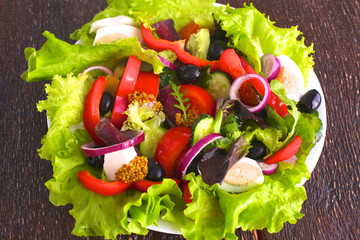 salad from fresh vegetables in a plate on a table, selective focus