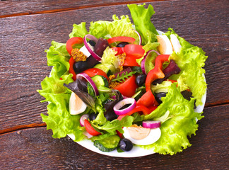 salad from fresh vegetables in a plate on a table, selective focus
