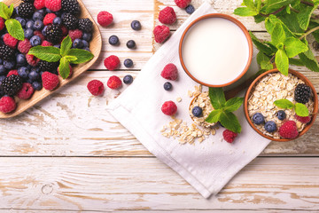 Raspberry, blackberry and blueberry, oatmeal breakfast with milk