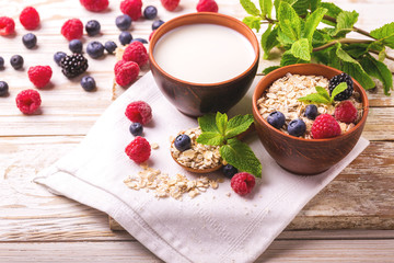 Raspberry, blackberry and blueberry, oatmeal breakfast with milk