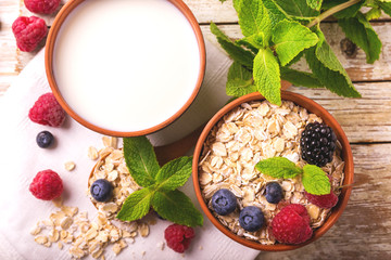 Raspberry, blackberry and blueberry, oatmeal breakfast with milk
