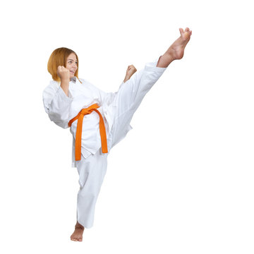 A girl strikes with a kick forward on a white background
