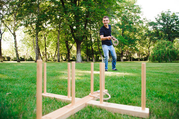 Outdoor games - guy playing ring toss in a park.