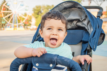 Child in a stroller in an amusement park