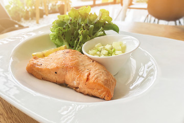 Delicious food homemade salmon steak  with fresh green salad and apple sauce.