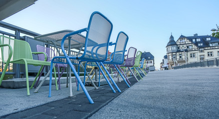 Fototapeta premium Pastelfarbene Stuhlreihe eines Restaurants bei den Brückenhäusern in Bad Kreuznach