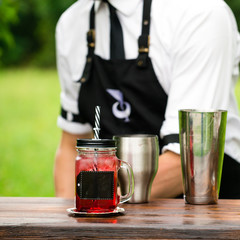 catering bar service. selective focus on a red cold lemonade in a mason jar with straw and ice cubes. Concept of summer, preparation cocktails, vacation, beverage relax, friends and fun