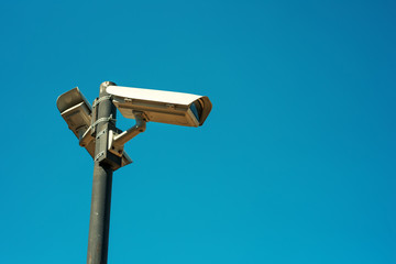 Two CCTV security cameras mounted on high post