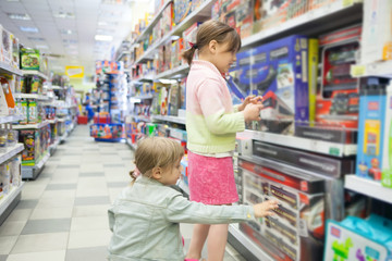 Two girls choosing   gift in   toy store