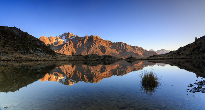 Panorama of the rocky peaks of Mount Disgrazia reflected in Lake Zana at dawn, Malenco Valley, Valtellina, Lombardy