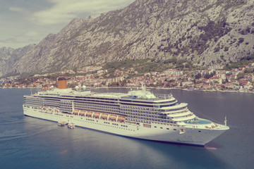 Beautiful white cruise ship on a background of mountains. Toned