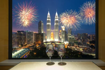 Foto op Canvas Closeup of a glasses of red wine at windowsill, against night Kuala lumpur city view of urban city sky line blurring lights. Malaysia. © ake1150