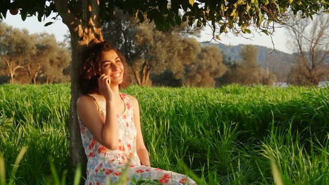 Young Woman Relaxing Reading Book Enjoying under Orange Tree