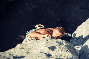 Men climbs a rock and put the rope into sling